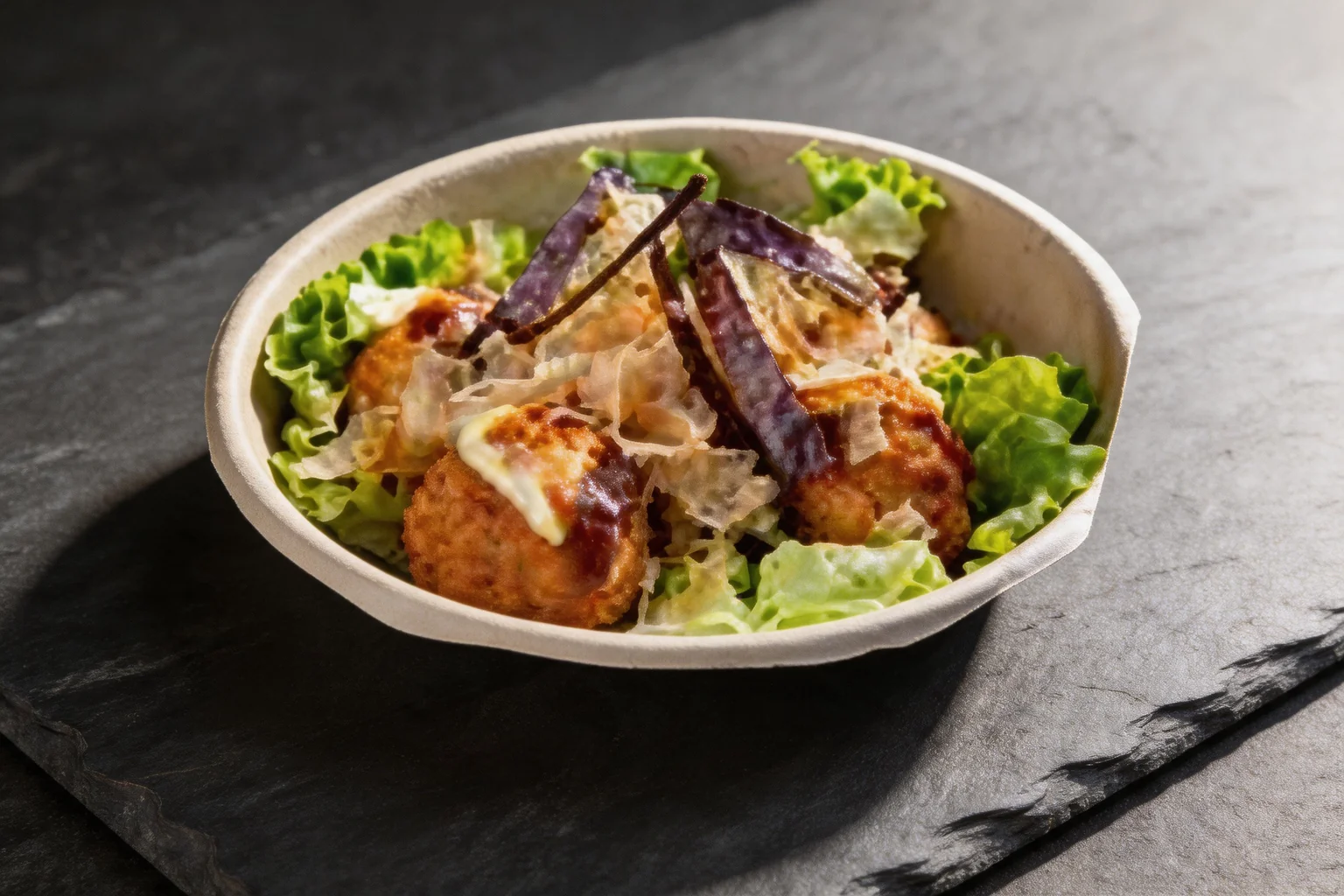 E4. Takoyaki in a bowl with lettuce, dark slate background